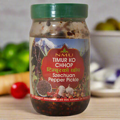 Jar of Szechuan Pepper Pickle with a red label and green lid on a white background